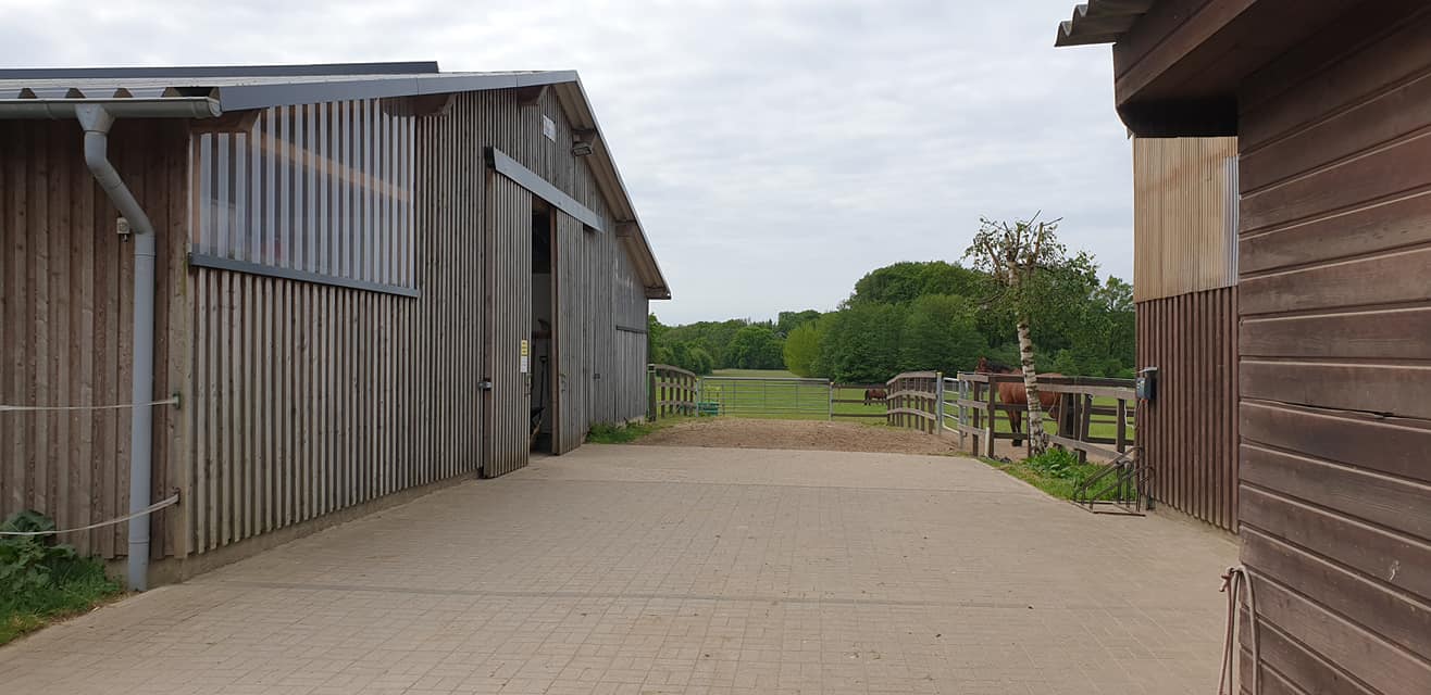 Weg zwischen den Ställen zur Weide