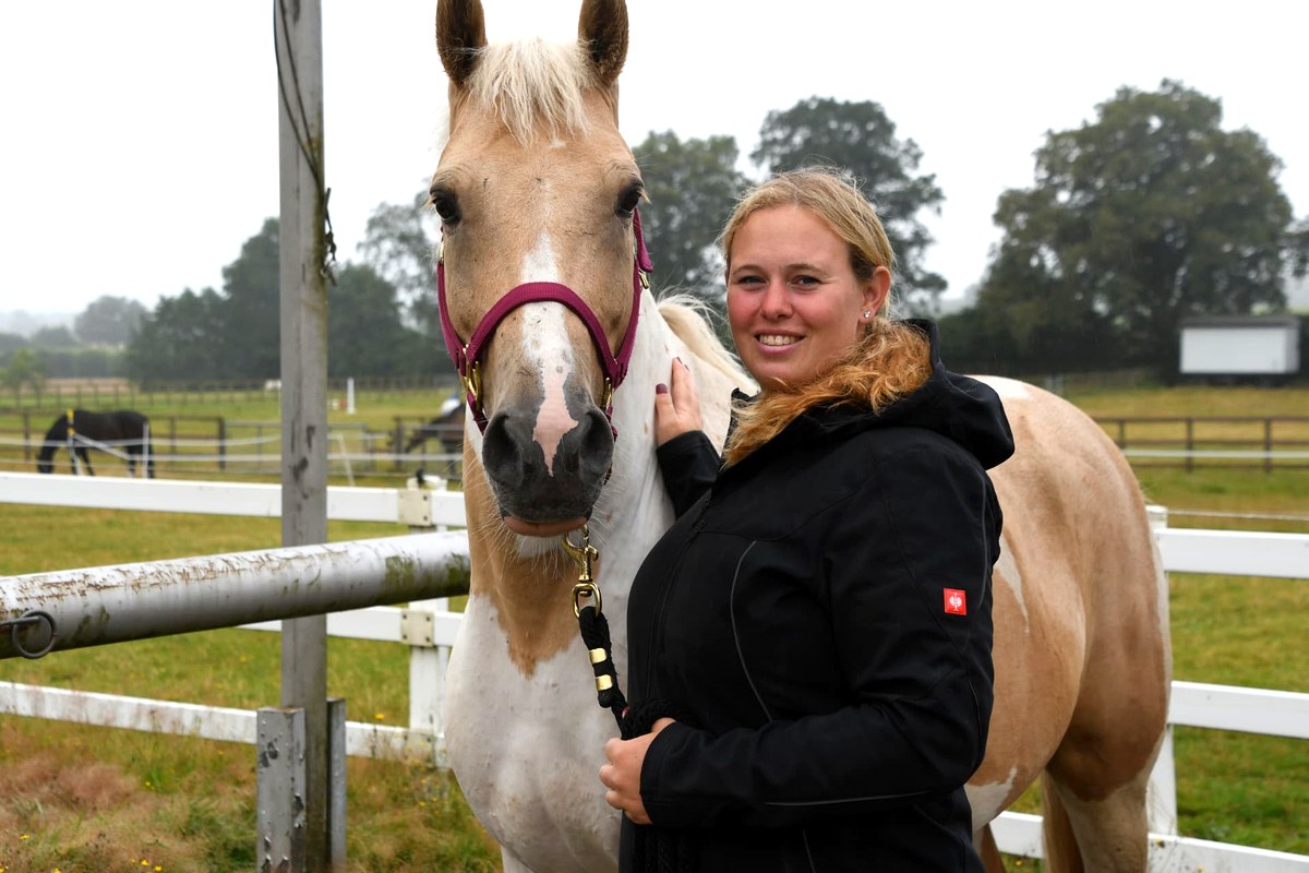 Monique Hecke, Inhaberin des Reitstalls Giese, mit einem Pferd auf der Koppel